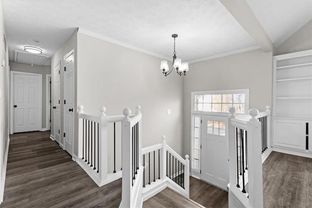 foyer entrance with vaulted ceiling, dark wood-type flooring, a chandelier, and a textured ceiling