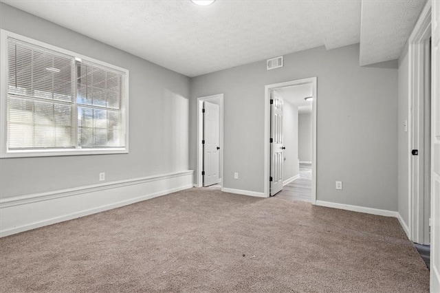 unfurnished bedroom with light carpet and a textured ceiling