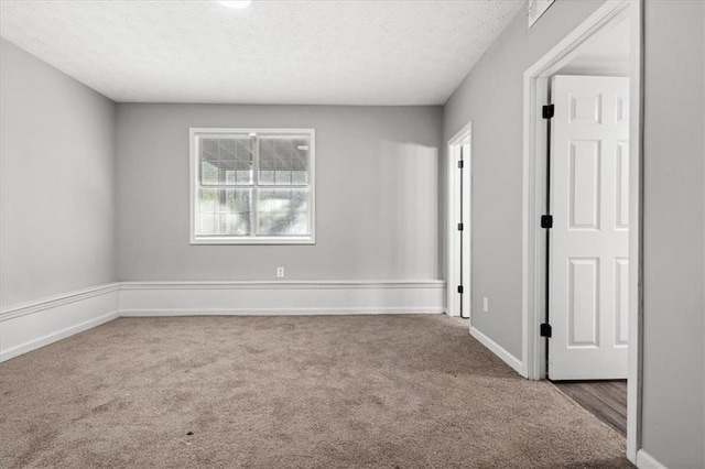 carpeted empty room featuring a textured ceiling