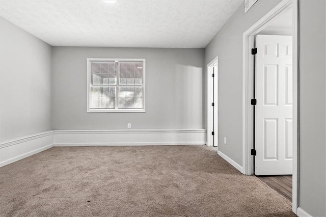 carpeted empty room with a textured ceiling