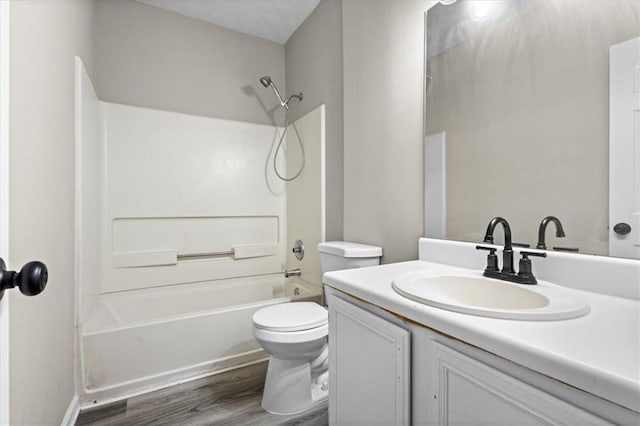 full bathroom with shower / washtub combination, hardwood / wood-style floors, vanity, toilet, and a textured ceiling