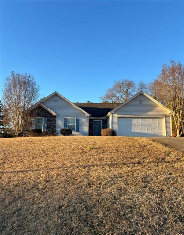 single story home with a front yard and a garage