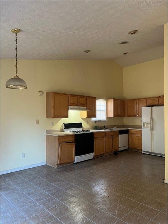 kitchen featuring sink, high vaulted ceiling, a textured ceiling, decorative light fixtures, and white appliances