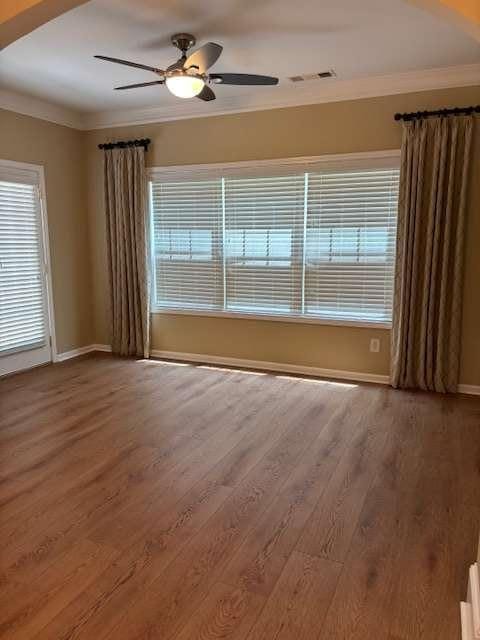 1629 Marsanne Ter, Kennesaw, GA 30152 - empty room with crown molding, baseboards, wood finished floors, and a ceiling fan