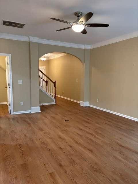 1629 Marsanne Ter, Kennesaw, GA 30152 - empty room featuring arched walkways, ornamental molding, wood finished floors, baseboards, and a ceiling fan