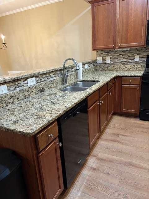 1629 Marsanne Ter, Kennesaw, GA 30152 - kitchen with black appliances, ornamental molding, light wood finished floors, a sink, and a peninsula