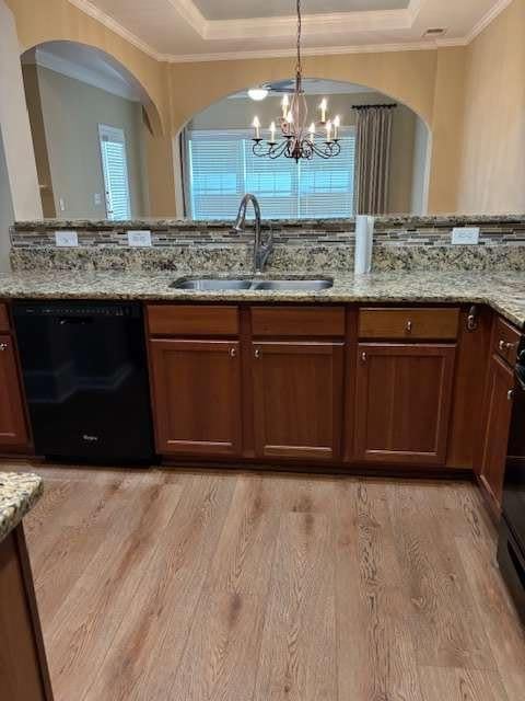 1629 Marsanne Ter, Kennesaw, GA 30152 - kitchen with dishwasher, a sink, a raised ceiling, a chandelier, and light wood-style floors