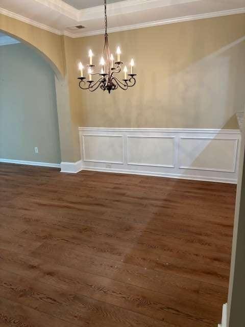 1629 Marsanne Ter, Kennesaw, GA 30152 - unfurnished dining area with arched walkways, a chandelier, dark wood-style flooring, crown molding, and baseboards