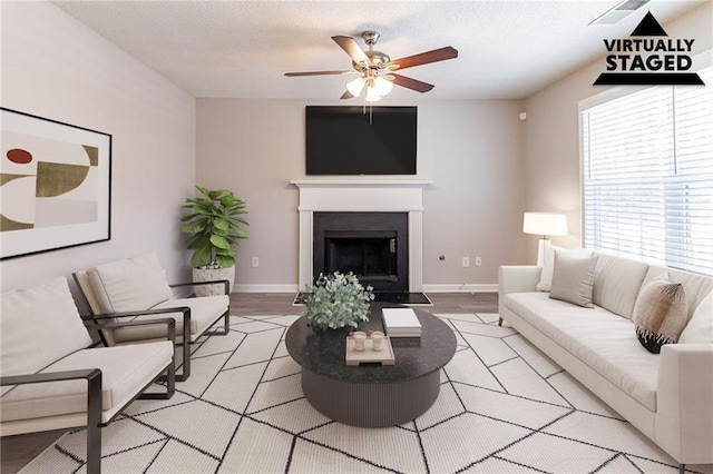 249 Bainbridge Cir, Dallas, GA 30132 - living room with baseboards, a textured ceiling, ceiling fan, and a fireplace