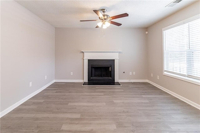 249 Bainbridge Cir, Dallas, GA 30132 - unfurnished living room with wood finished floors, a ceiling fan, visible vents, a fireplace, and a textured ceiling