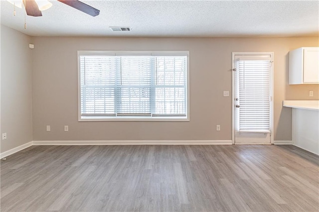 249 Bainbridge Cir, Dallas, GA 30132 - interior space featuring a ceiling fan, baseboards, visible vents, light wood-style floors, and a textured ceiling