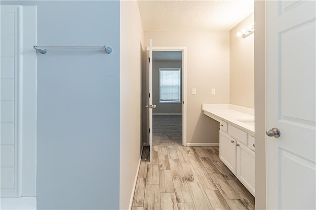 249 Bainbridge Cir, Dallas, GA 30132 - bathroom featuring a textured ceiling, vanity, baseboards, and wood tiled floor