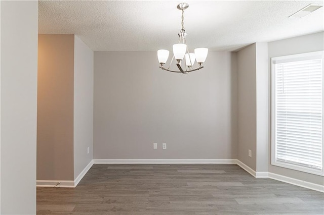 249 Bainbridge Cir, Dallas, GA 30132 - unfurnished room featuring visible vents, a textured ceiling, an inviting chandelier, and wood finished floors