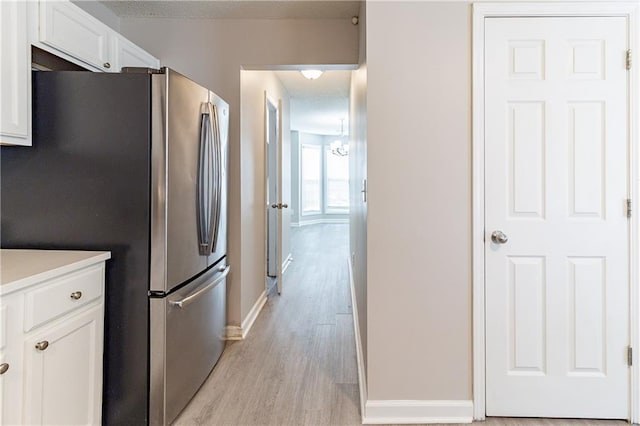 249 Bainbridge Cir, Dallas, GA 30132 - kitchen with freestanding refrigerator, light wood-style floors, white cabinets, light countertops, and baseboards