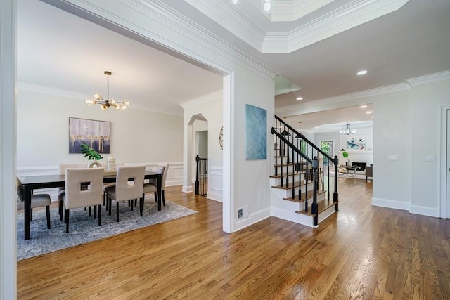 dining room featuring hardwood / wood-style flooring, an inviting chandelier, and ornamental molding