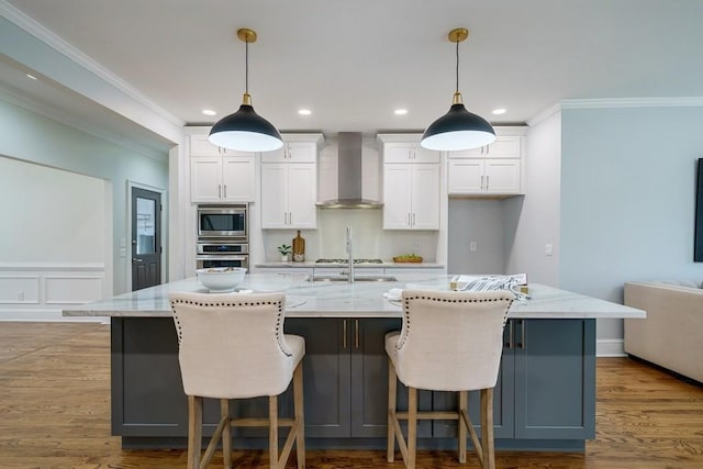 kitchen featuring a large island and wall chimney exhaust hood