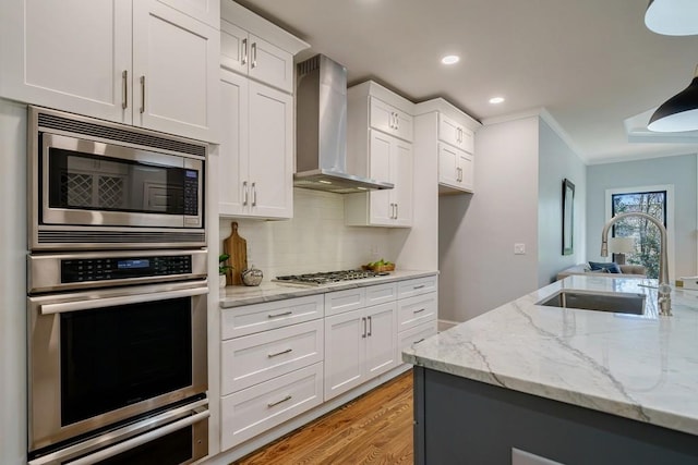 kitchen with white cabinetry, sink, wall chimney exhaust hood, and appliances with stainless steel finishes