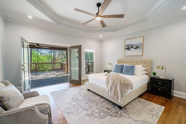 bedroom featuring access to exterior, wood-type flooring, a tray ceiling, and ceiling fan