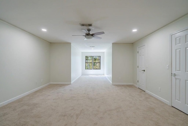 empty room with ceiling fan, ornamental molding, and light carpet