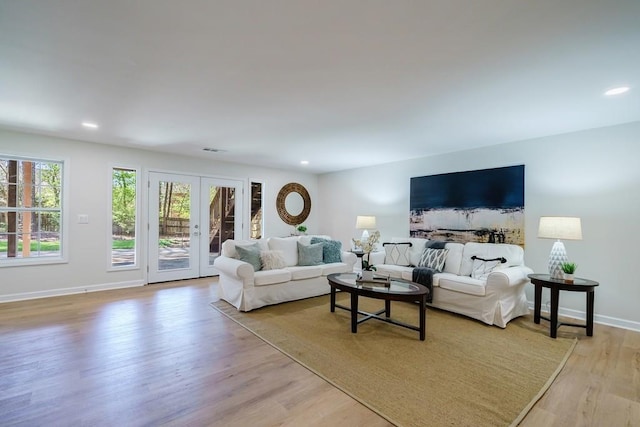 living room featuring french doors and light hardwood / wood-style flooring