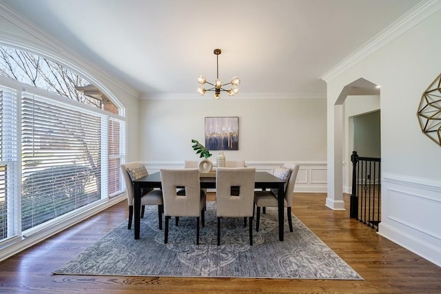 dining room featuring dark hardwood / wood-style flooring, an inviting chandelier, a wealth of natural light, and crown molding