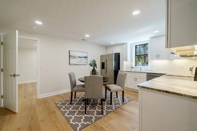 dining area with light hardwood / wood-style flooring and sink