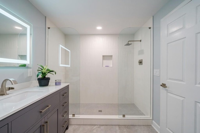 bathroom featuring a tile shower and vanity