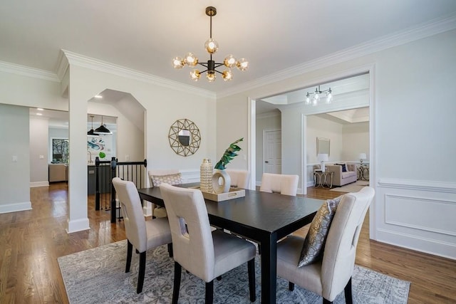 dining room with hardwood / wood-style floors, crown molding, and a chandelier