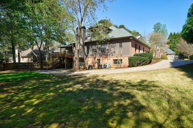 back of property with a wooden deck and a lawn