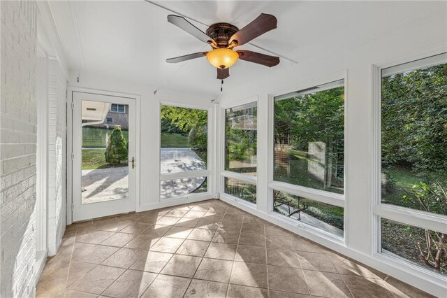 unfurnished sunroom with a healthy amount of sunlight and ceiling fan