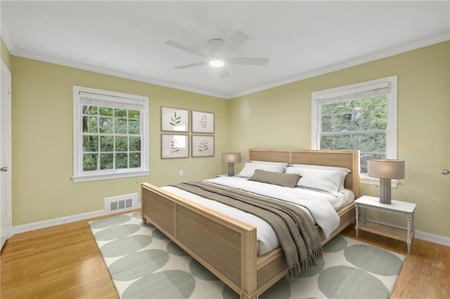 bedroom featuring light hardwood / wood-style flooring, multiple windows, and ceiling fan