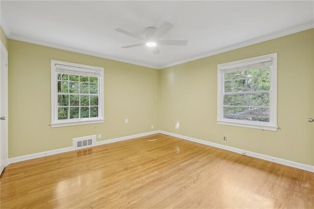 unfurnished room featuring ceiling fan, light wood-type flooring, crown molding, and a healthy amount of sunlight