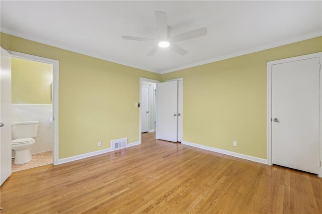 unfurnished bedroom featuring ornamental molding, light hardwood / wood-style floors, ensuite bathroom, and ceiling fan