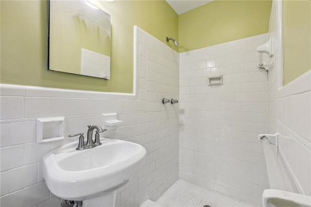 bathroom featuring a shower with shower curtain, tile walls, and sink