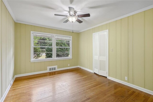 interior space with ceiling fan, hardwood / wood-style flooring, a closet, and ornamental molding