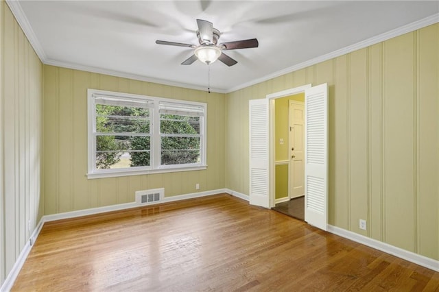 unfurnished bedroom with ceiling fan, hardwood / wood-style flooring, and crown molding