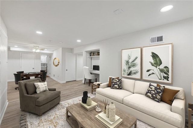 living room with ceiling fan and light hardwood / wood-style floors