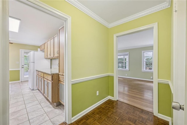 hall with crown molding and light tile patterned floors