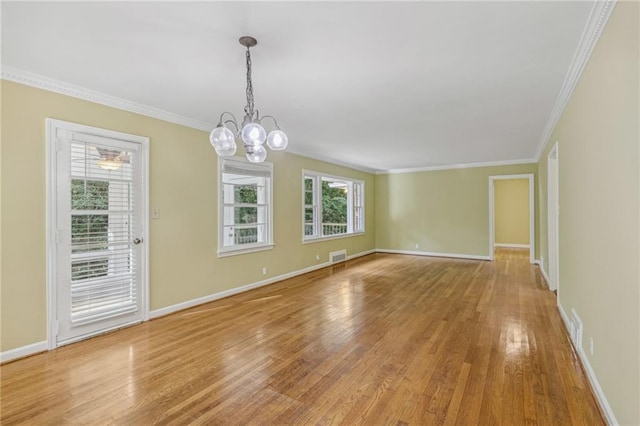 unfurnished room featuring wood-type flooring, an inviting chandelier, and ornamental molding