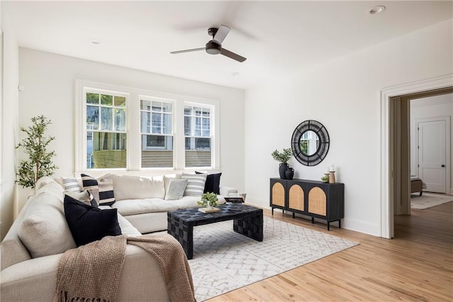 living room featuring light wood-style flooring, baseboards, ceiling fan, and recessed lighting