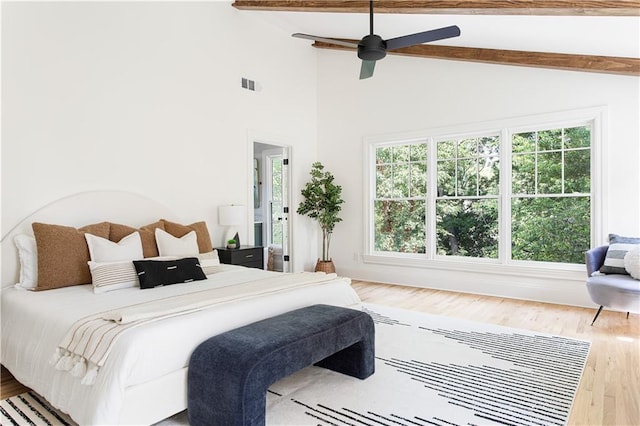 bedroom with lofted ceiling with beams, wood finished floors, visible vents, and a ceiling fan