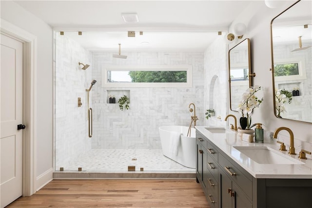 full bath featuring a tile shower, wood finished floors, a soaking tub, and a sink