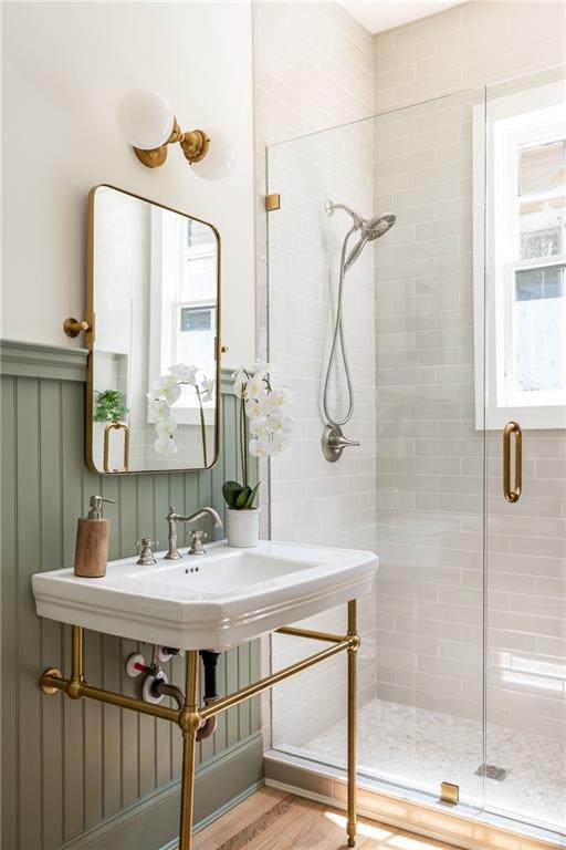 full bathroom with a stall shower and wood finished floors