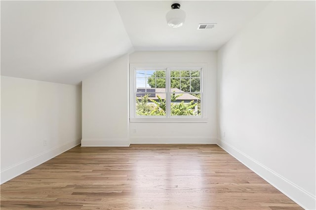 bonus room with light wood-type flooring, baseboards, visible vents, and lofted ceiling