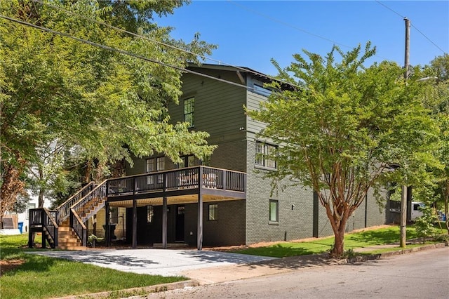 view of building exterior featuring driveway and stairs