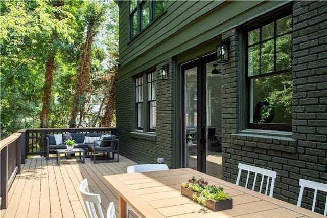 wooden terrace with an outdoor hangout area, french doors, and outdoor dining space