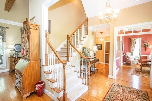1145 Thurston Snow Rd, Good Hope, GA 30641 - staircase featuring crown molding, wood finished floors, a chandelier, and a high ceiling