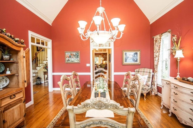 1145 Thurston Snow Rd, Good Hope, GA 30641 - dining area featuring lofted ceiling, a chandelier, ornamental molding, light wood-type flooring, and stairway