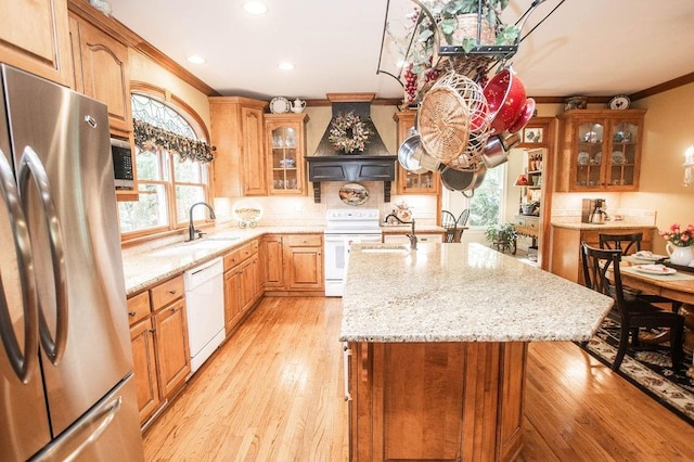1145 Thurston Snow Rd, Good Hope, GA 30641 - kitchen featuring white appliances, premium range hood, crown molding, healthy amount of natural light, and a kitchen island with sink