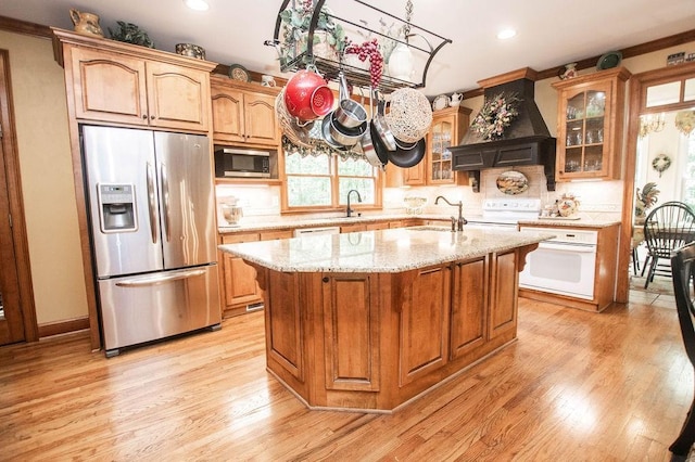 1145 Thurston Snow Rd, Good Hope, GA 30641 - kitchen with appliances with stainless steel finishes, custom exhaust hood, glass insert cabinets, a kitchen island with sink, and tasteful backsplash